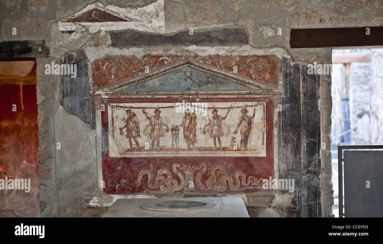 Lararium (Santuario) fresco en el atrio de la antigua taberna Pompeya Italia Foto de stock
