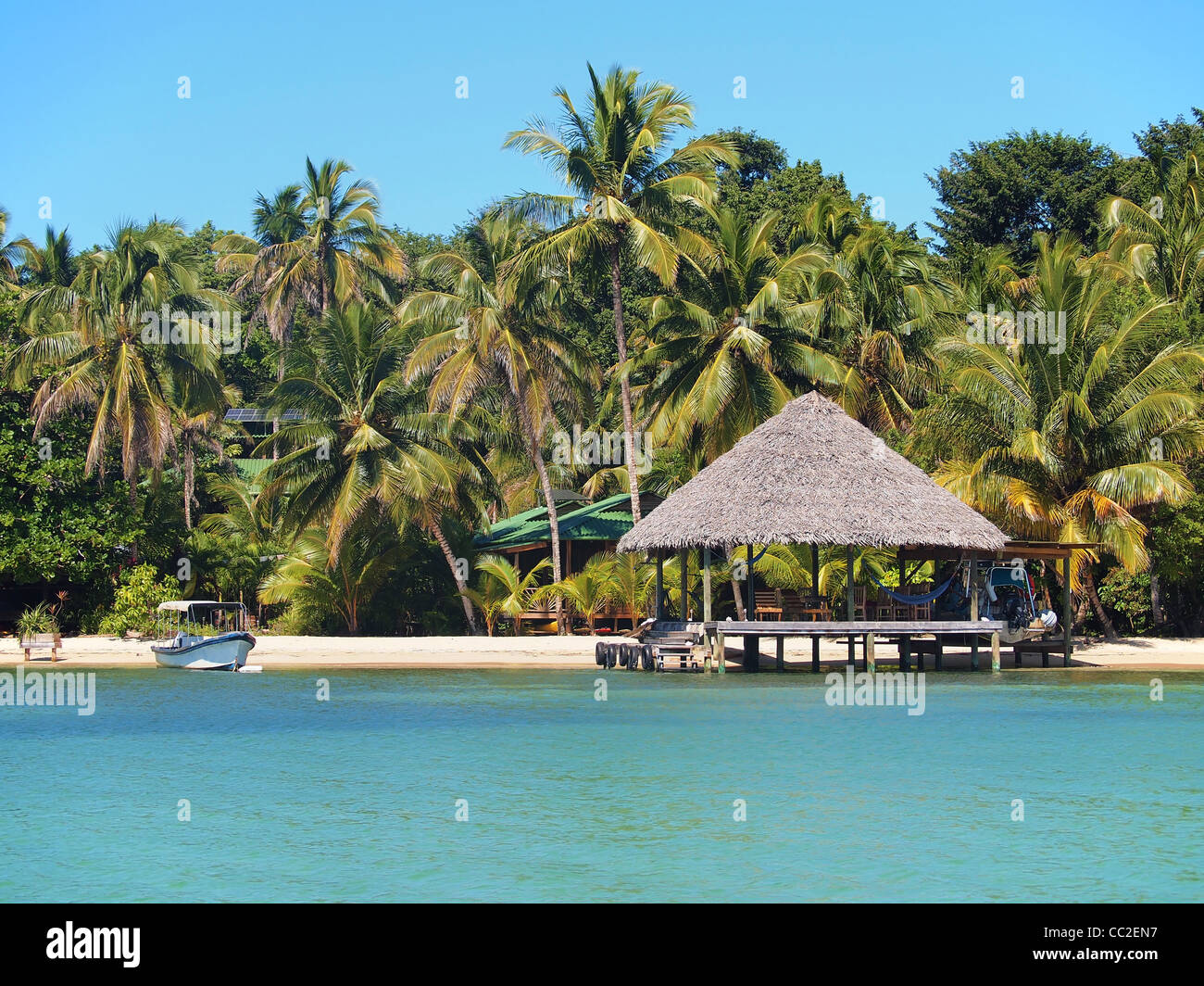 Playa Tropical con cabaña sobre el agua y cocoteros, parte del Caribe de Panamá, América Central Foto de stock
