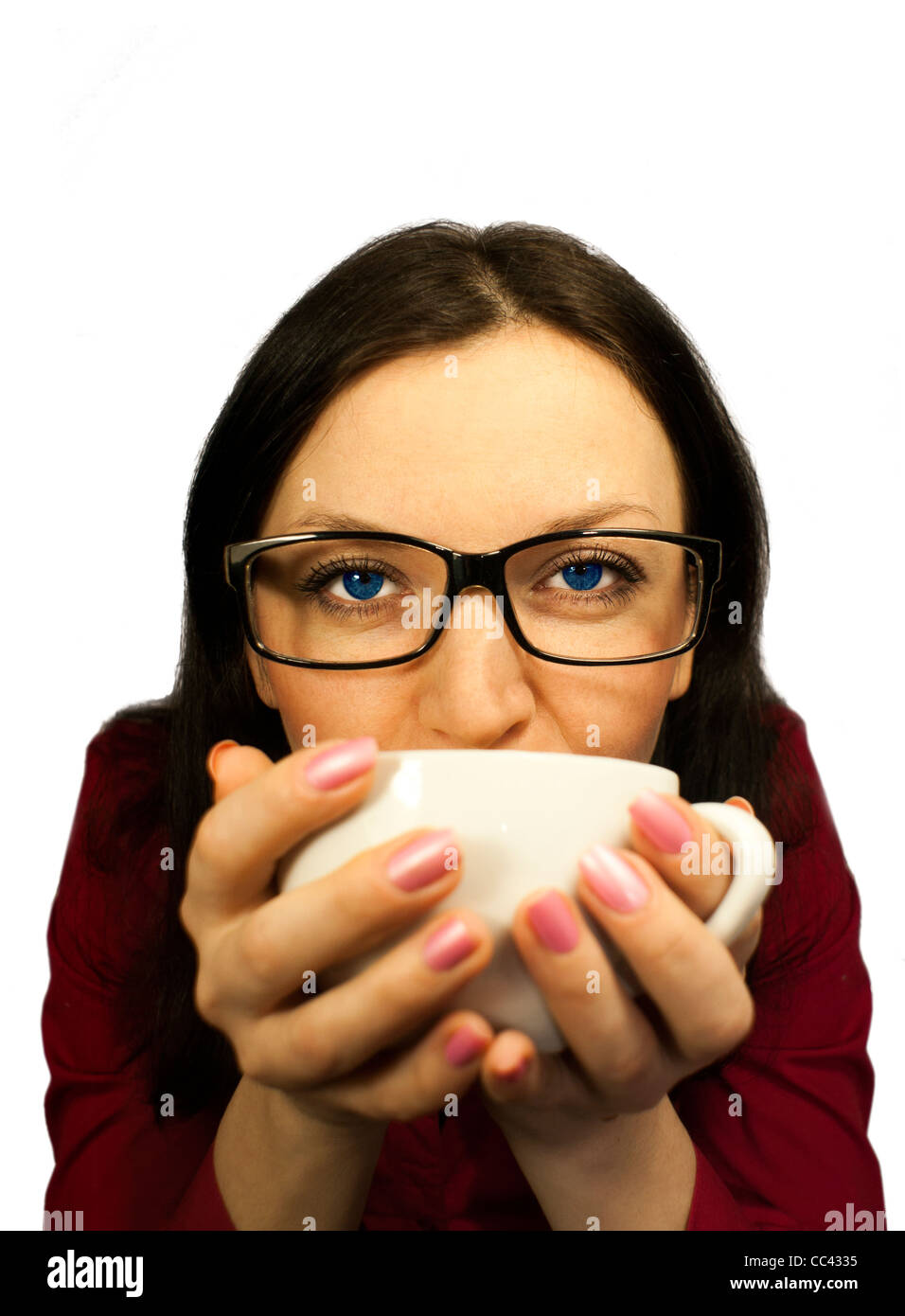 Niña morena con gafas intentando café condimentado Foto de stock