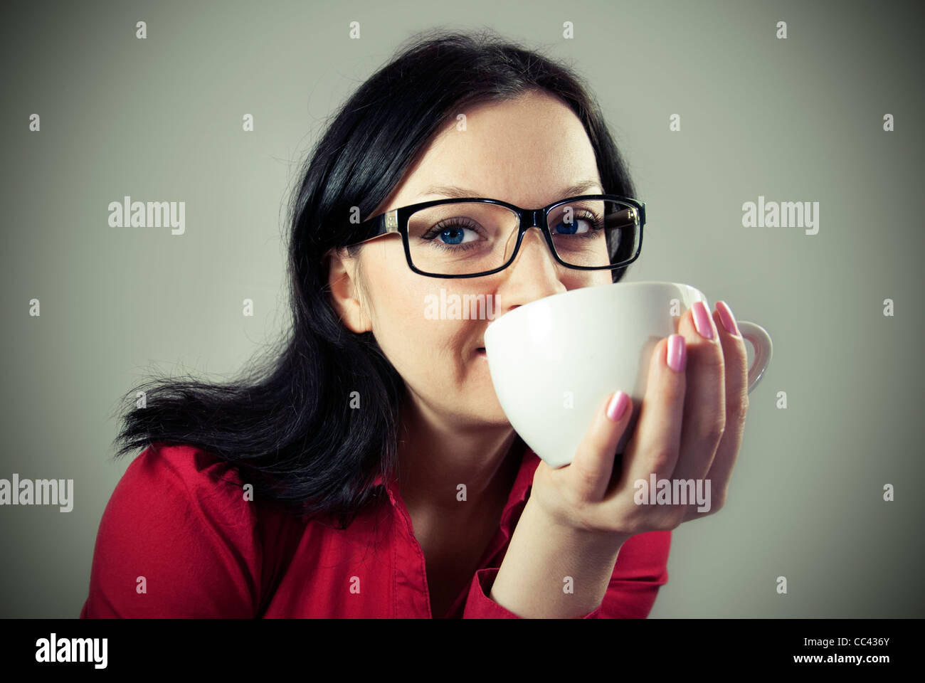 Niña morena con gafas intentando café condimentado Foto de stock