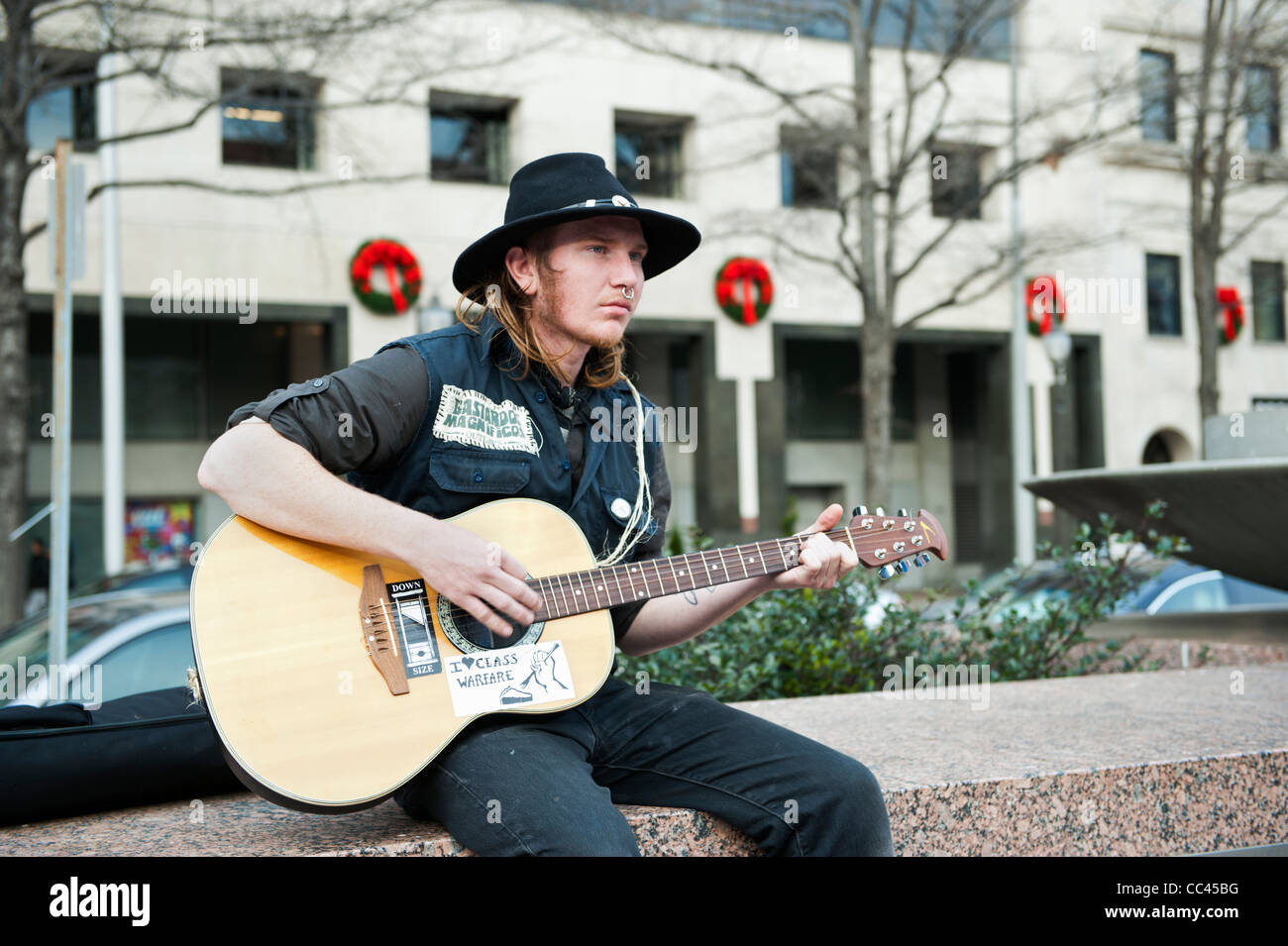 Un participante del movimiento DC ocupan tocar una guitarra en la Plaza de la libertad en Washington DC. Foto de stock