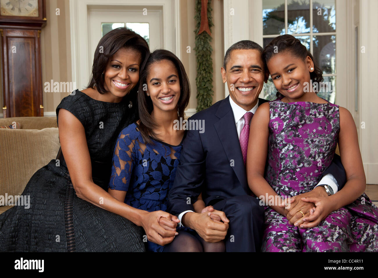 El presidente Barack Obama, la Primera Dama Michelle Obama, y sus hijas, Sasha y Malia, sentarse un retrato de familia en la Oficina Oval Foto de stock