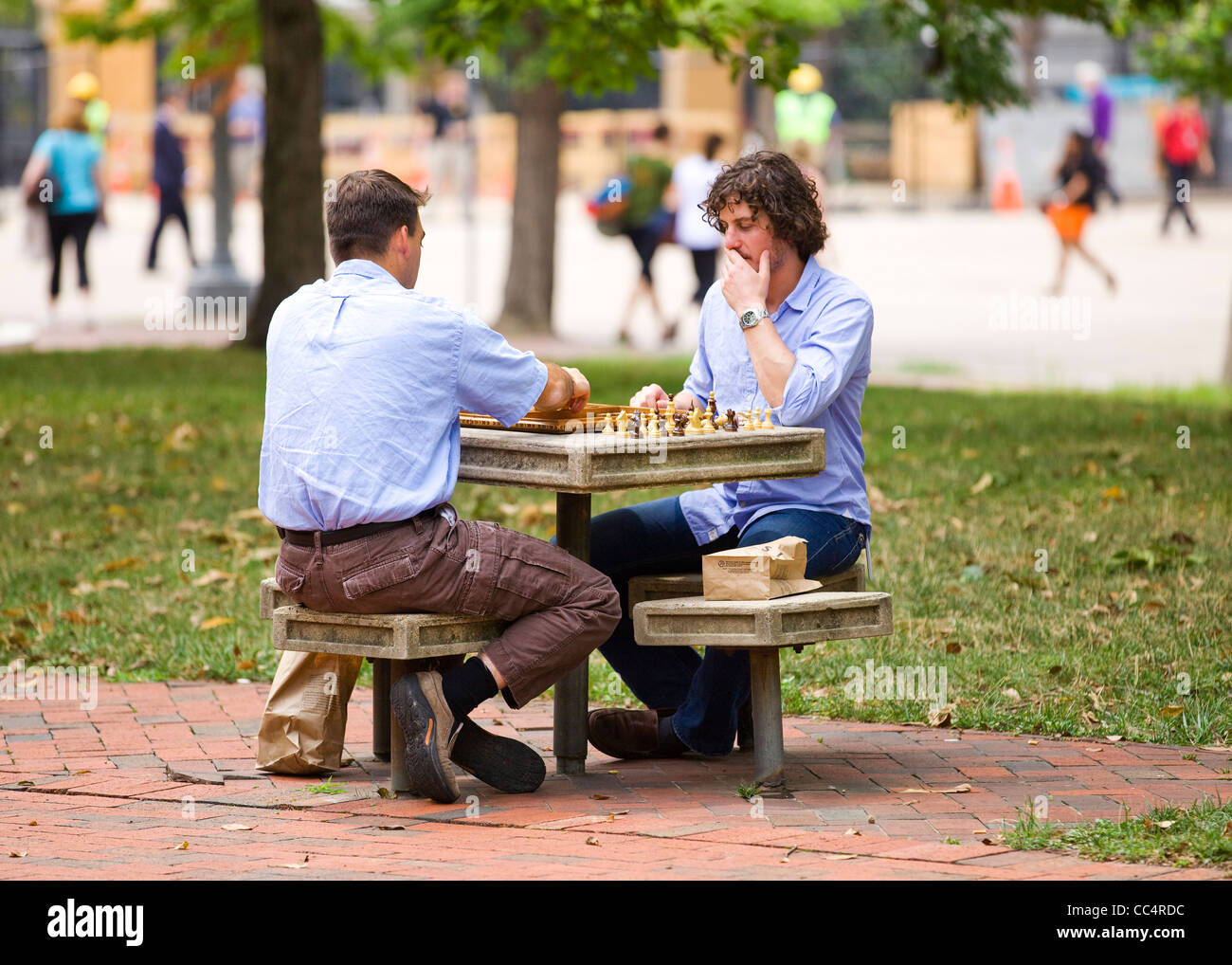 Los hombres jugando al ajedrez en un parque al aire libre mesa - EE.UU. Foto de stock