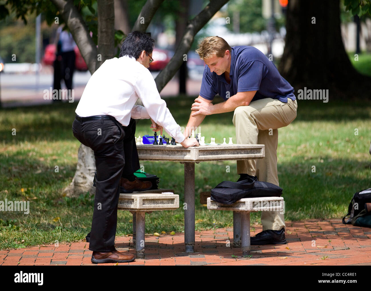 Los hombres jugando al ajedrez en un parque al aire libre mesa - EE.UU. Foto de stock