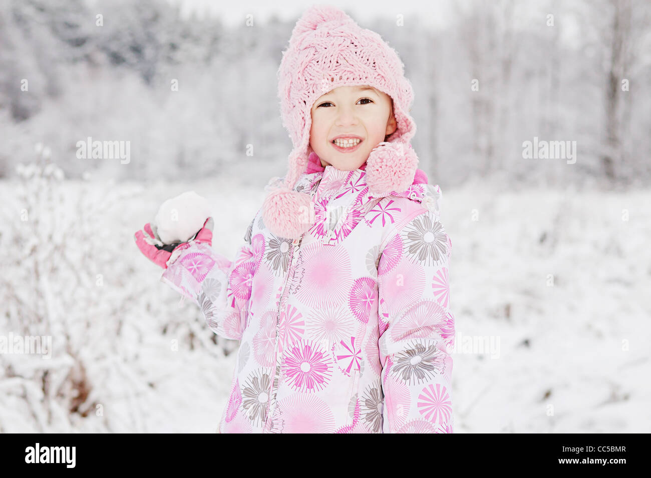Un retrato de una niña con una bola de nieve Foto de stock