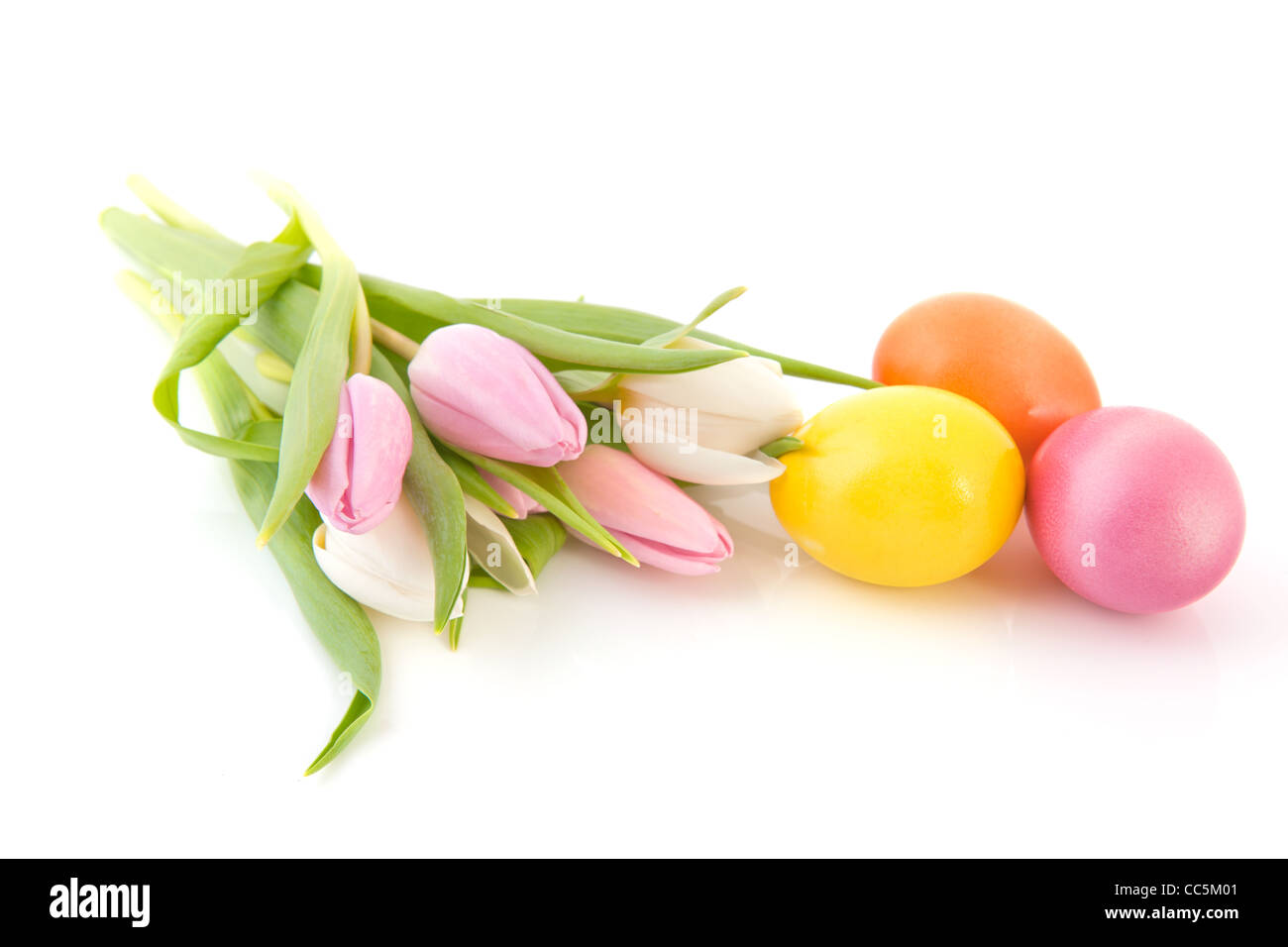 Huevos de pascua de colores pastel y tulipanes Foto de stock