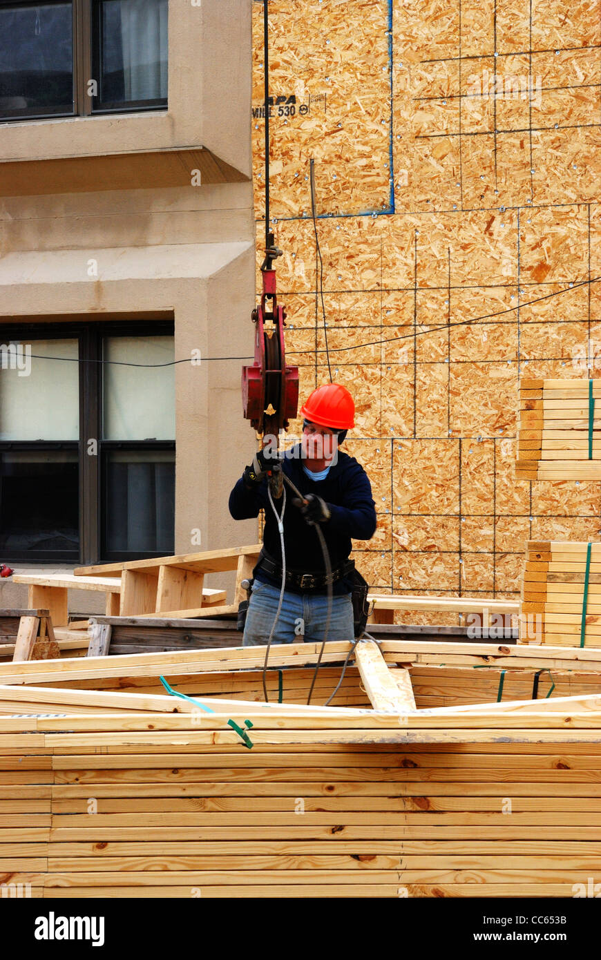 Carpenter en la pila de vigas prefabricadas. Foto de stock