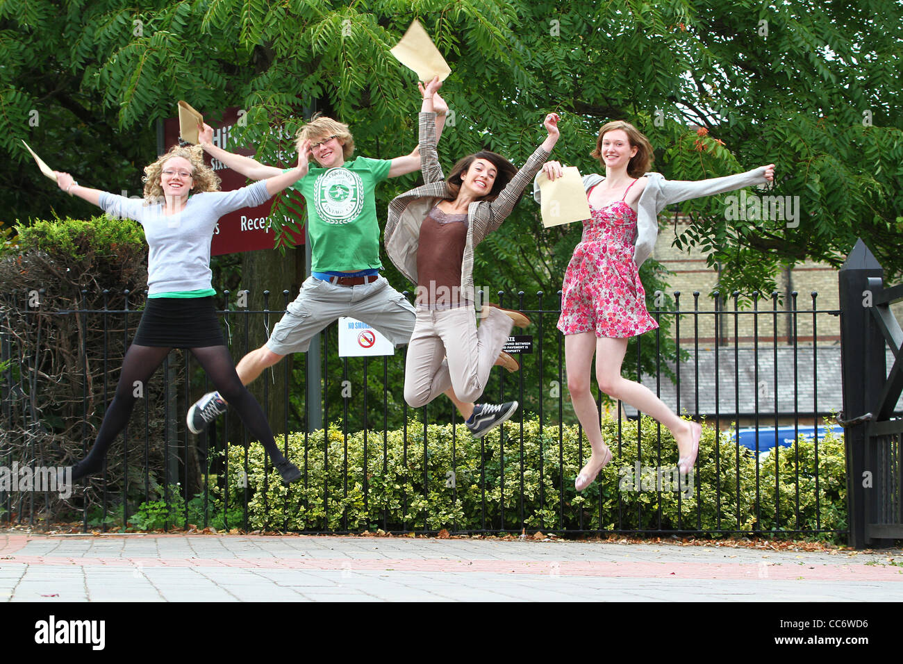 Estudiantes de bachillerato saltar de alegría al recibir sus resultados de final de mandato en Cambridge, Inglaterra. Foto de stock