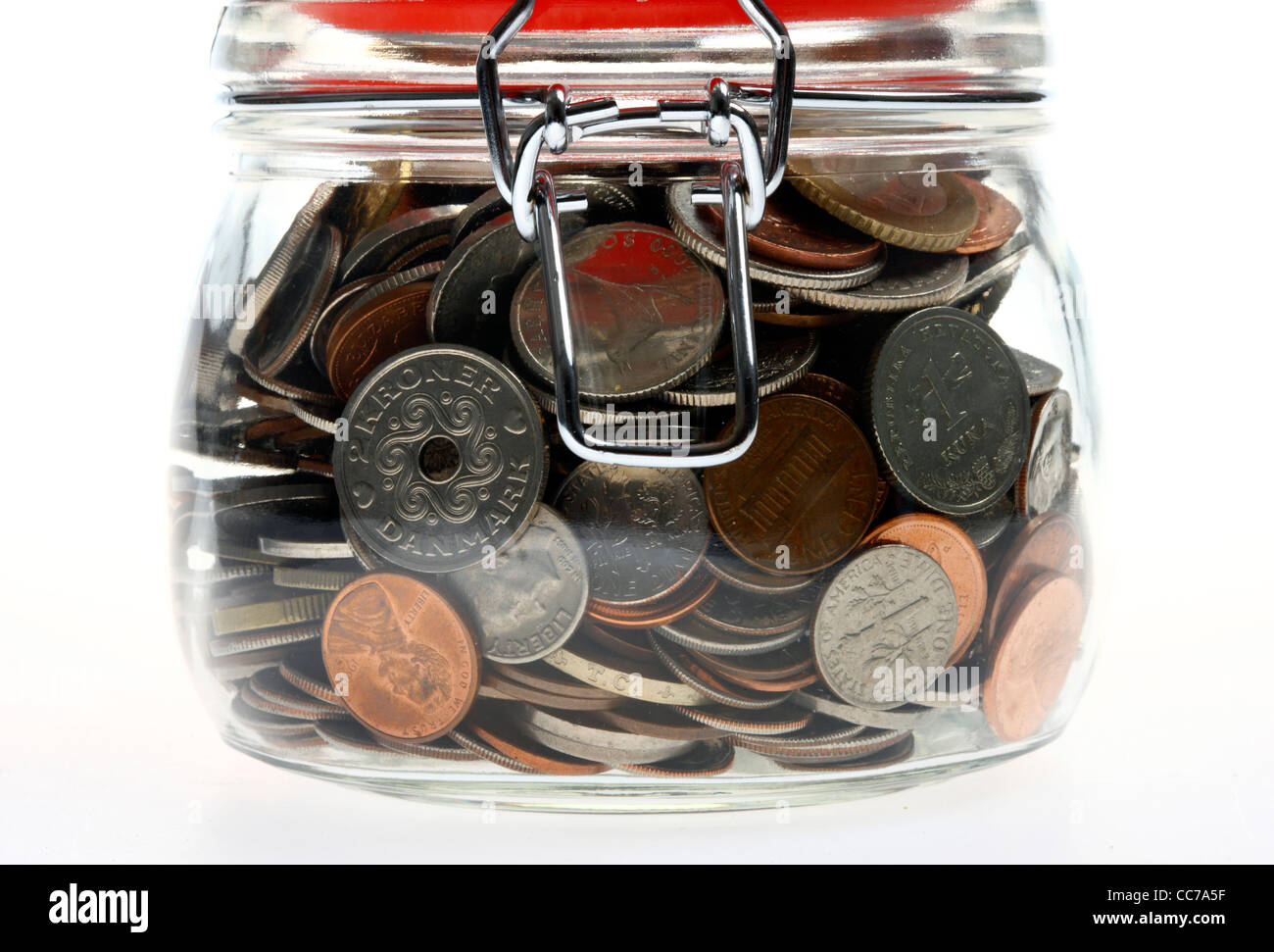 Dinero en un tarro de vidrio, preservar, monedas, diferentes tipos de monedas, de diferentes países, diferentes de la moneda. Foto de stock