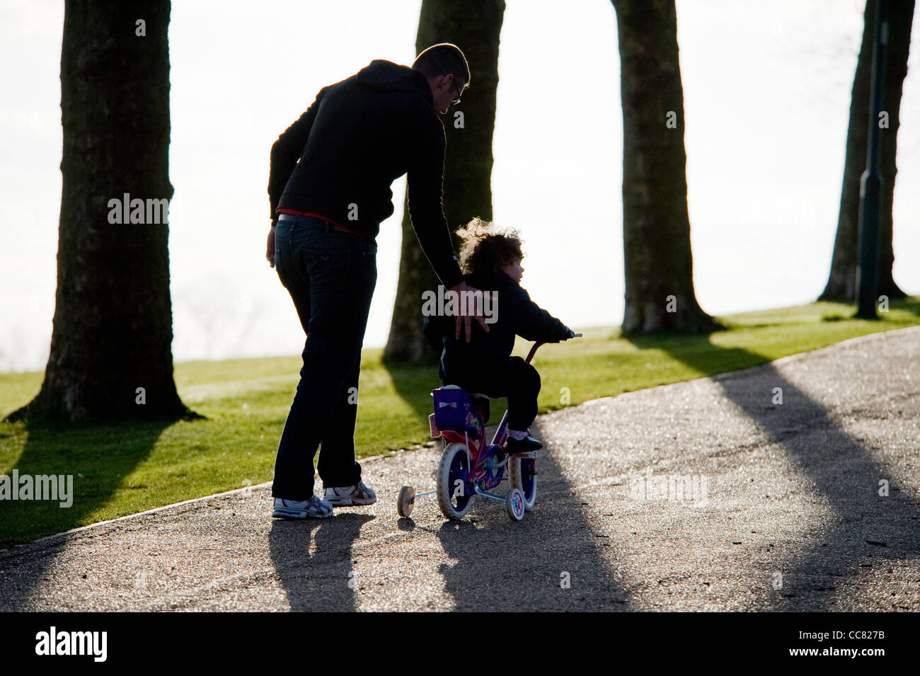 El padre y el hijo en la cuna de moto en Gladstone Park en un soleado día de primavera Foto de stock