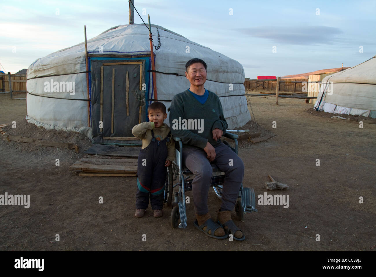 Discapacitados hombre mongol y su hijo delante de su ger Erdenet Mongolia Foto de stock
