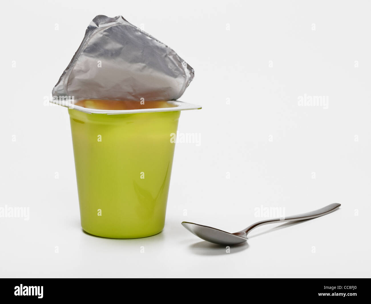 Eines Detailansicht Joghurtbechers, daneben liegt ein kleiner Löffel | Detalle foto de una taza de yogur, junto a una pequeña cuchara Foto de stock