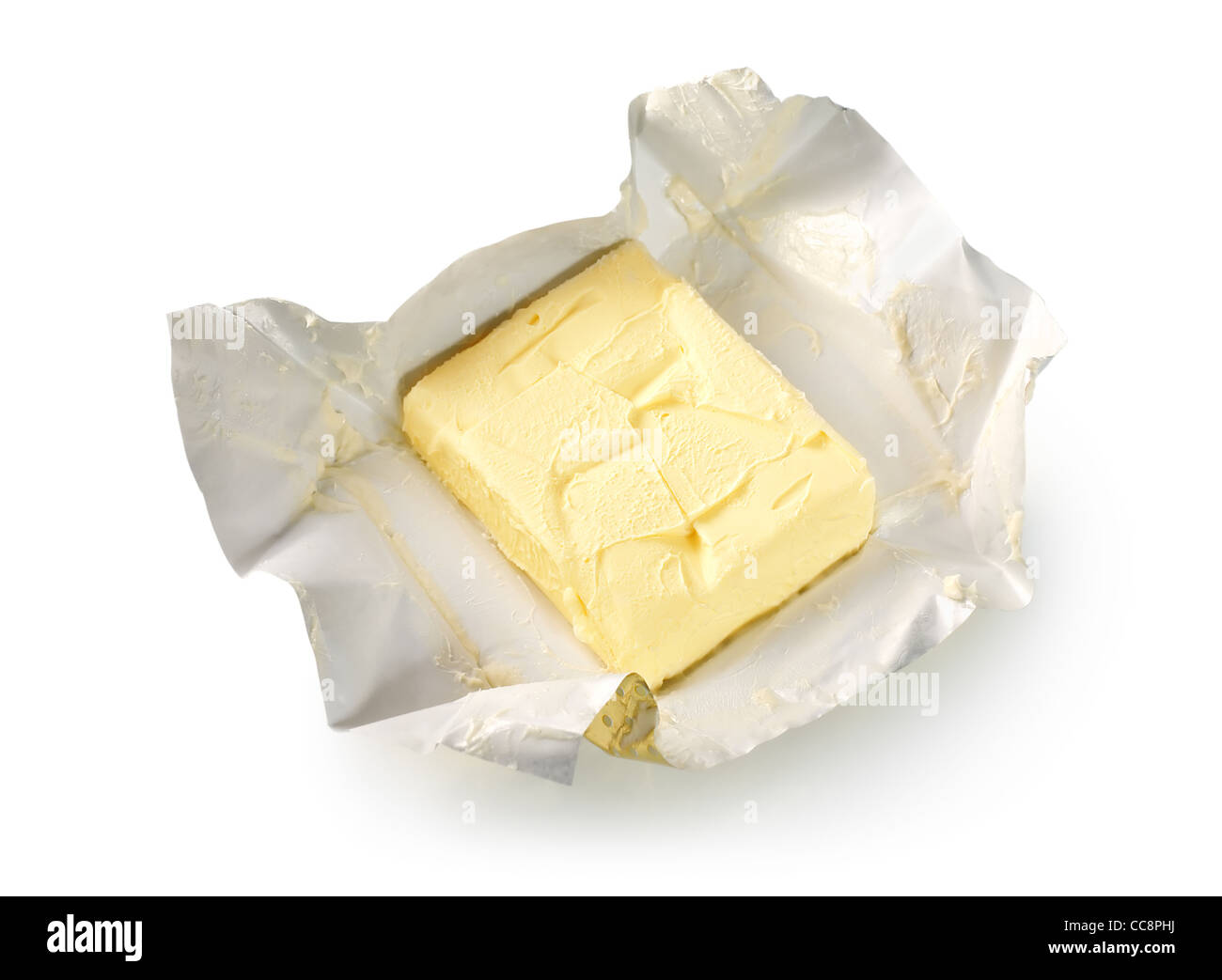 Cremoso de mantequilla en su papel de aluminio sin envasar. Aislado en blanco (Ruta) Foto de stock