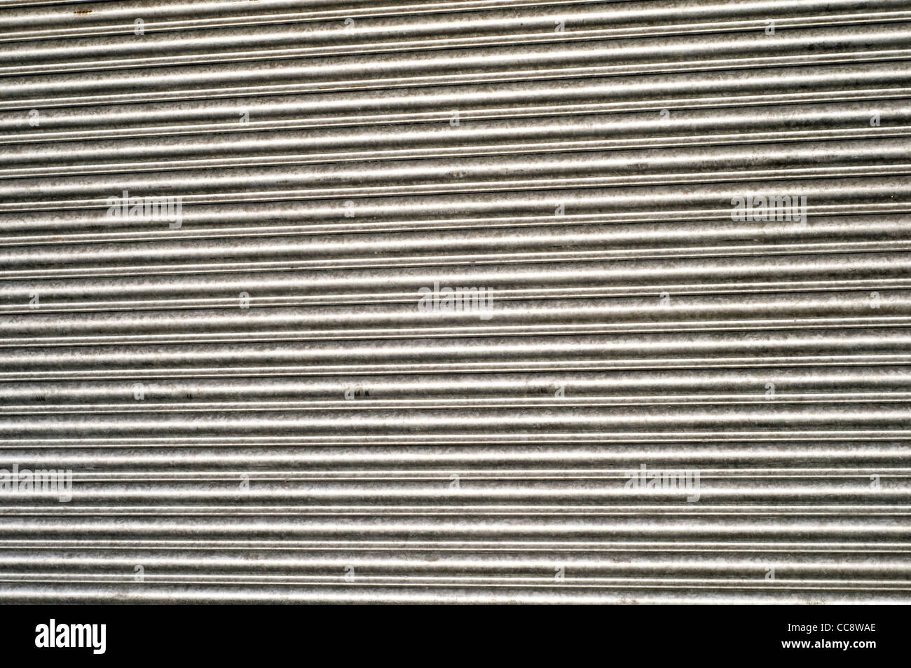 Detalle de persianas de metal cerrados en un escaparate en el Reino Unido, destacando el impacto de la recesión y la crisis económica Foto de stock