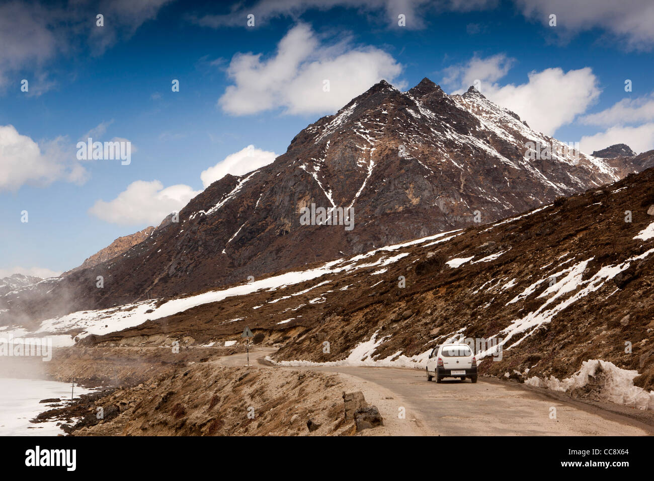 La India, Arunachal Pradesh, el SELA Pass, coche circulando por la carretera elevada altitud pasado lago congelado Foto de stock