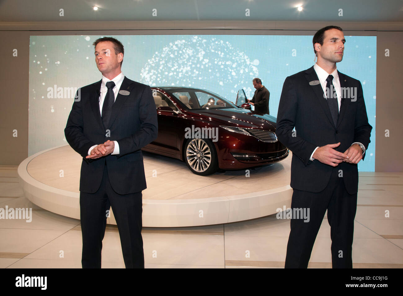 Modelos vestidos como agentes de seguridad protegen el 2013 Lincoln MKZ en el Auto Show de Detroit Foto de stock