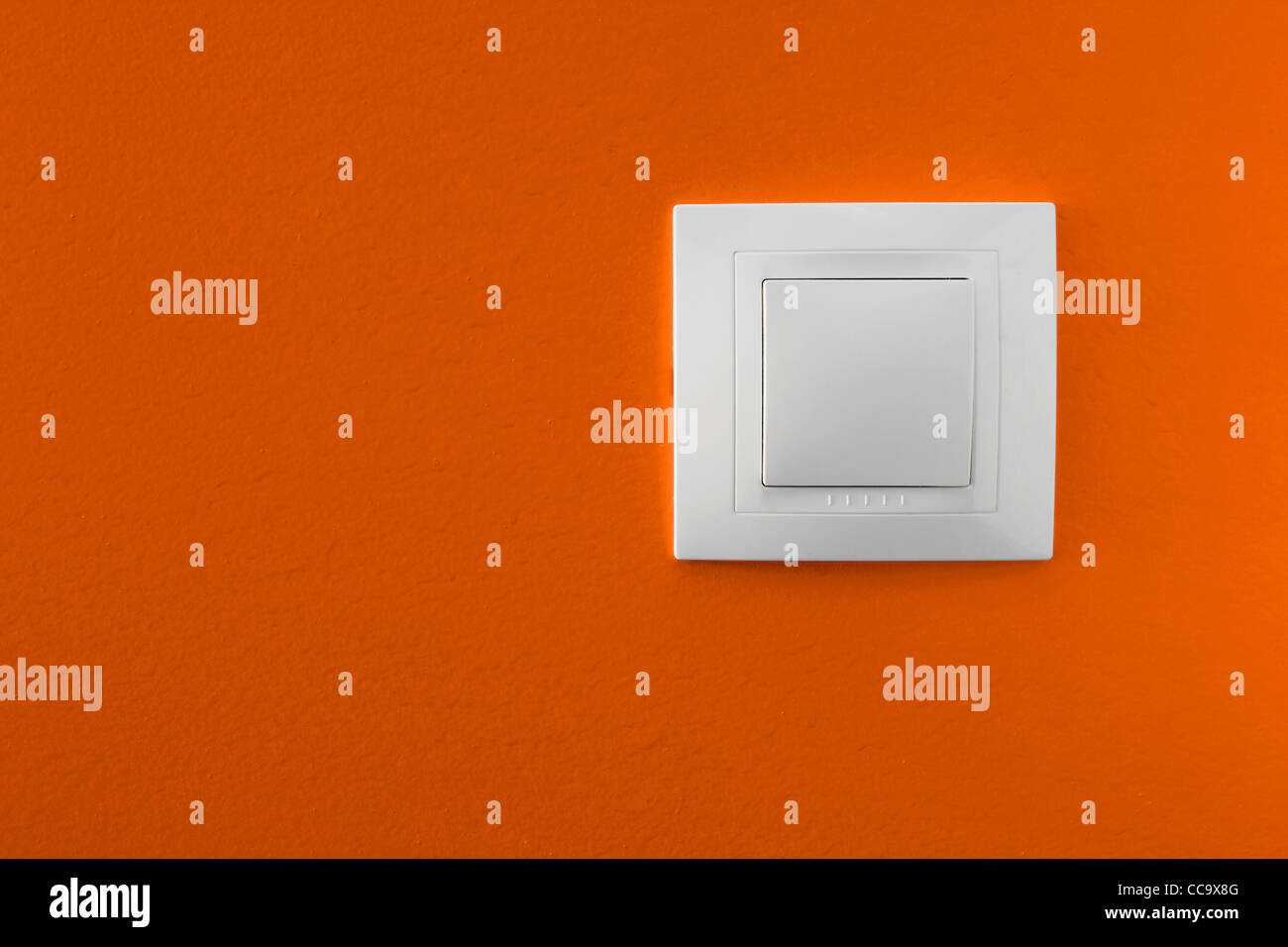 Interruptor de luz simple sobre una pared naranja Foto de stock