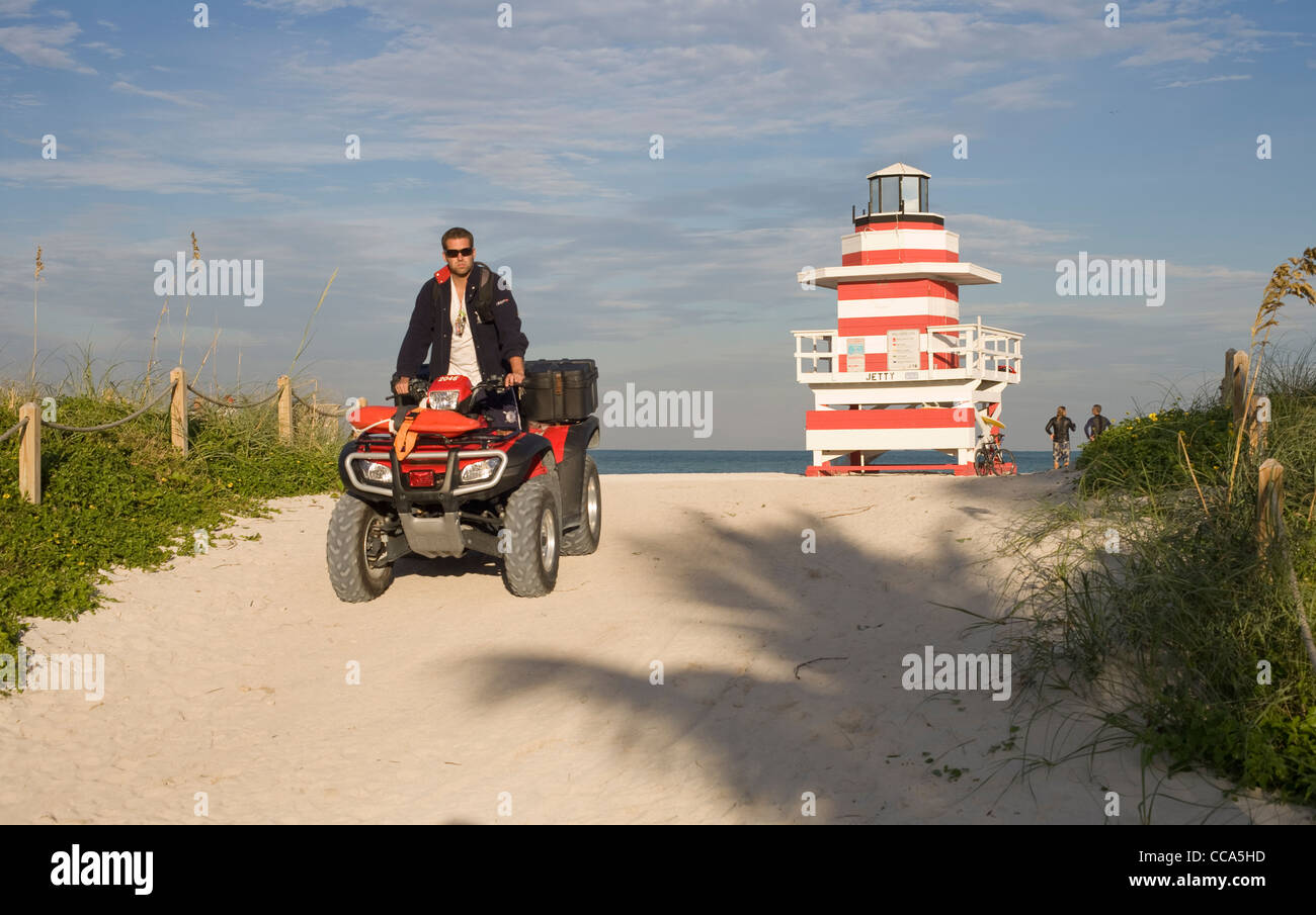 Un socorrista conduce un buggy en South Beach Miami con un socorrista station en el fondo Foto de stock