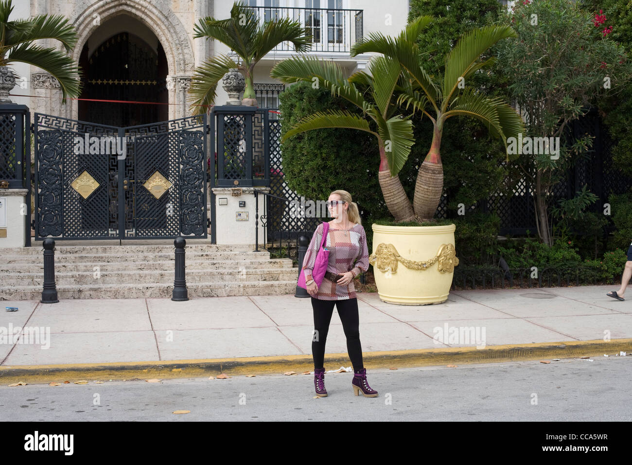Chica posando delante de la antigua casa de Gianni Versace en Ocean Drive de Miami Foto de stock