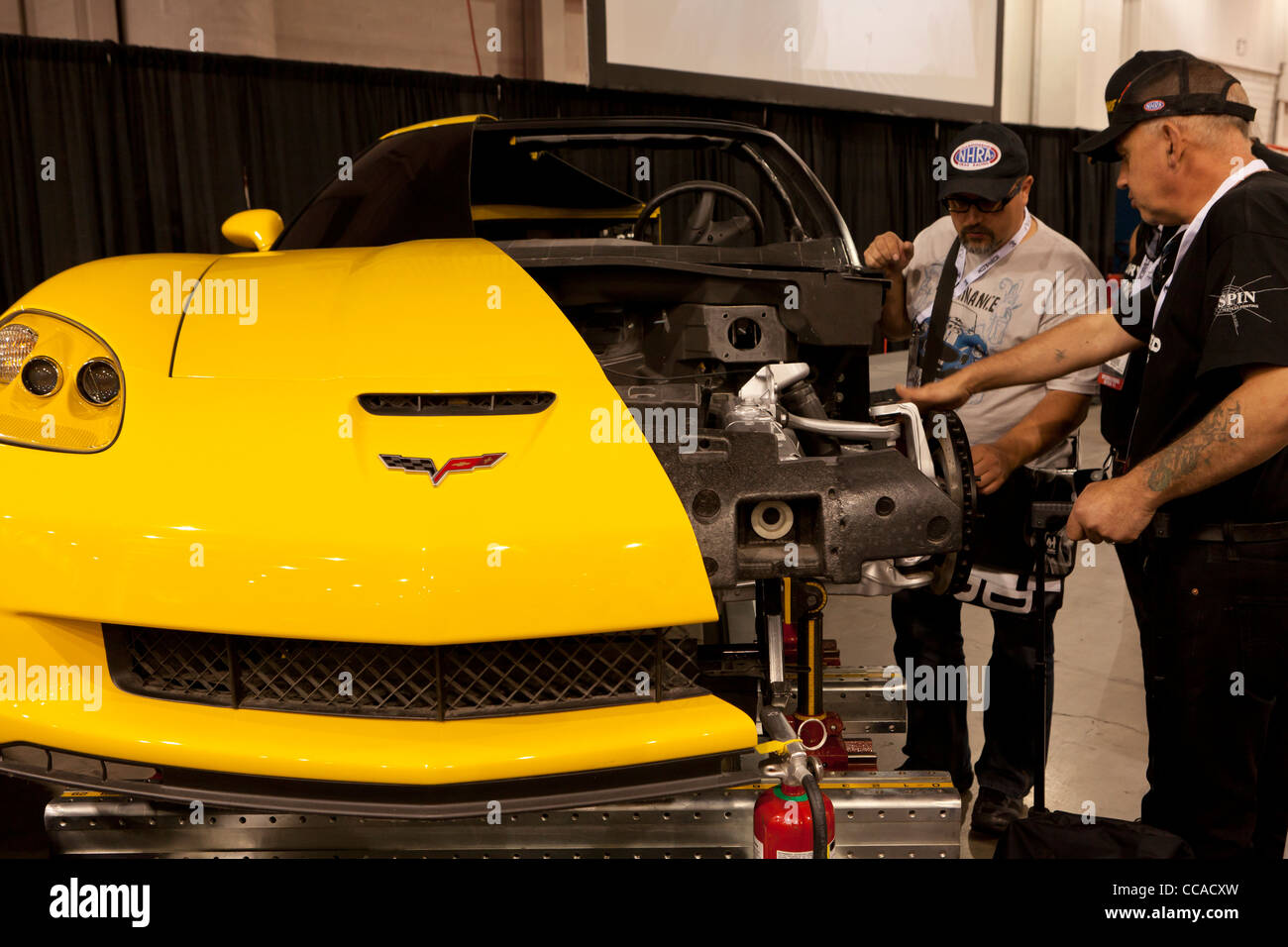 Dos mecánicos inspeccionando un modelo recortado de coche Foto de stock