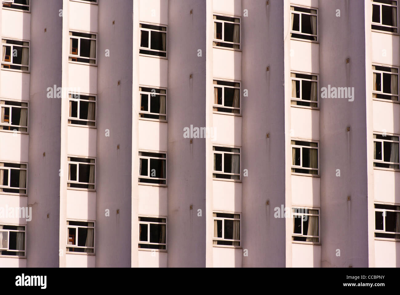Patrones Patrón simétrico simétrico simétricamente ventanas en un edificio moderno de hormigón Foto de stock