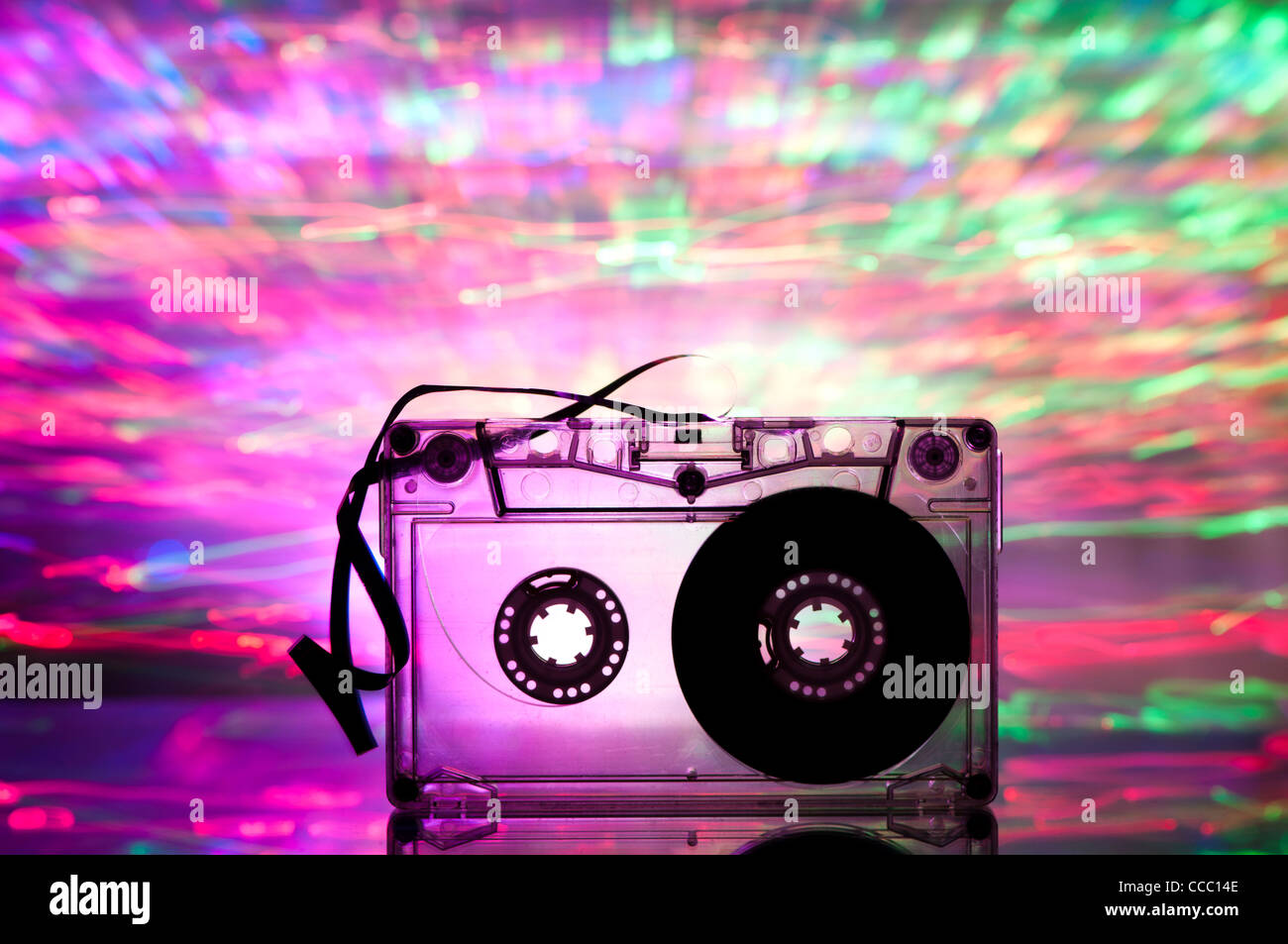 Cinta de cassette y multicolores luces azules sobre fondo rosa Foto de stock