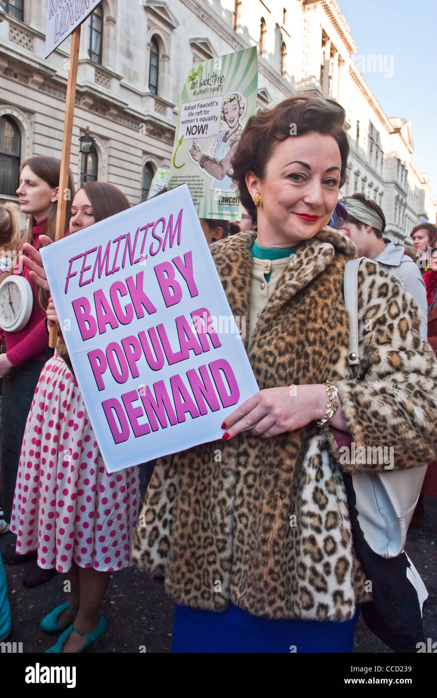 Etiqueta "Feminismo, de regreso por demanda popular" organizado por la mujer sonriente vestida en 1950 faux ropa de leopardo, protesta contra el 'cortes'. Foto de stock