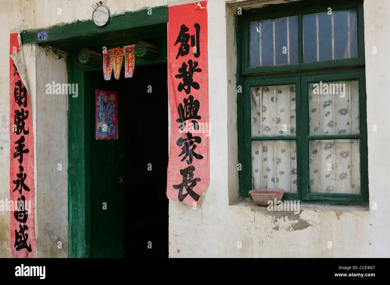 Duilian pergaminos de poesía colgando fuera una puerta verde Fuli en la República Popular de China Foto de stock