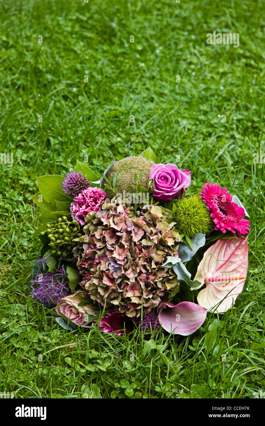 Bouquet con flores de verano tardío en la hierba antecedentes - vertical Foto de stock
