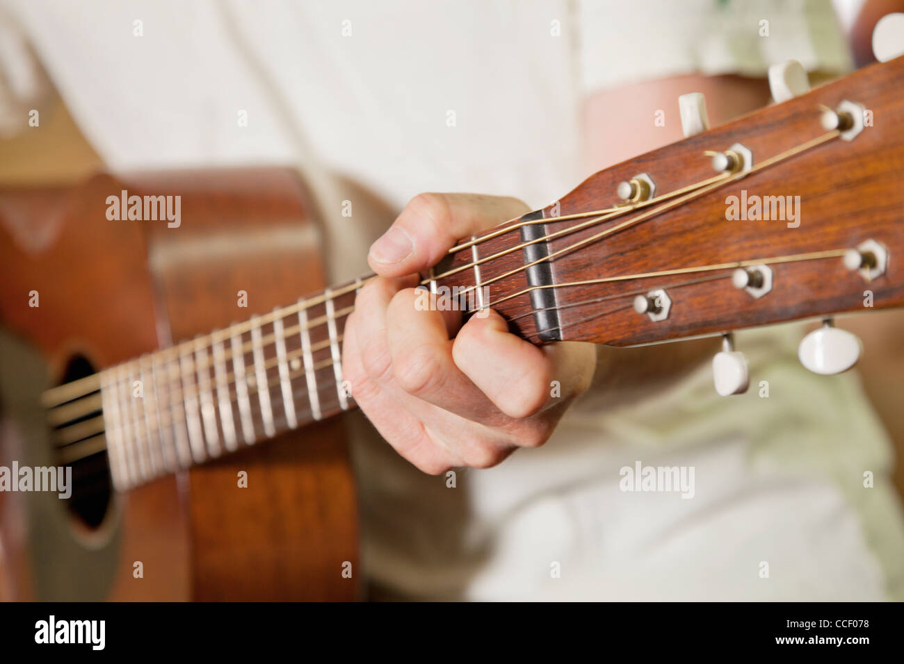 Vista cercana de la mano del hombre tocando la guitarra Foto de stock