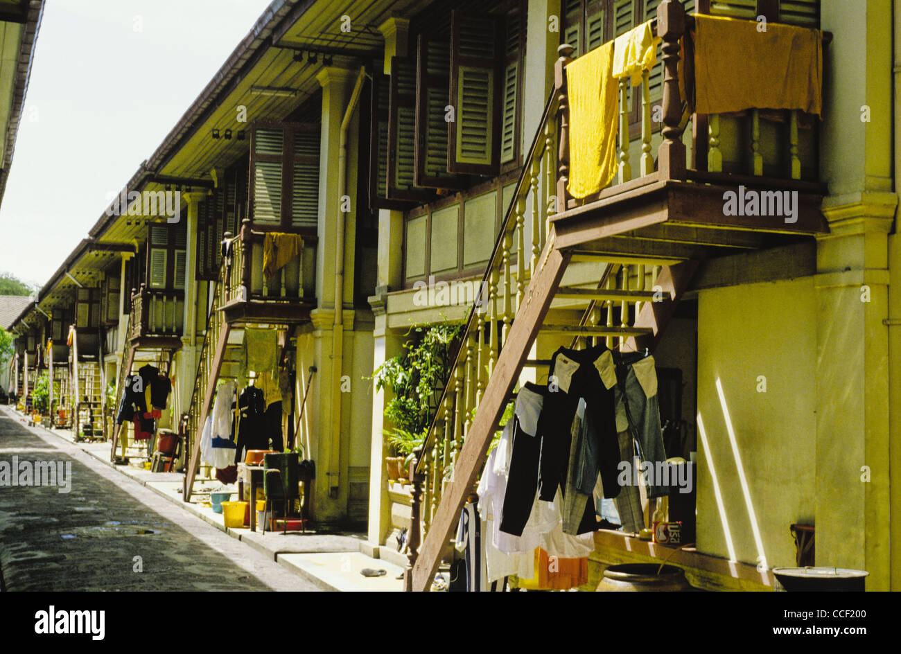 Arquitectura que muestra dos pisos edificio de apartamentos con lavandería secándose en las escaleras, Bangkok, Tailandia Foto de stock