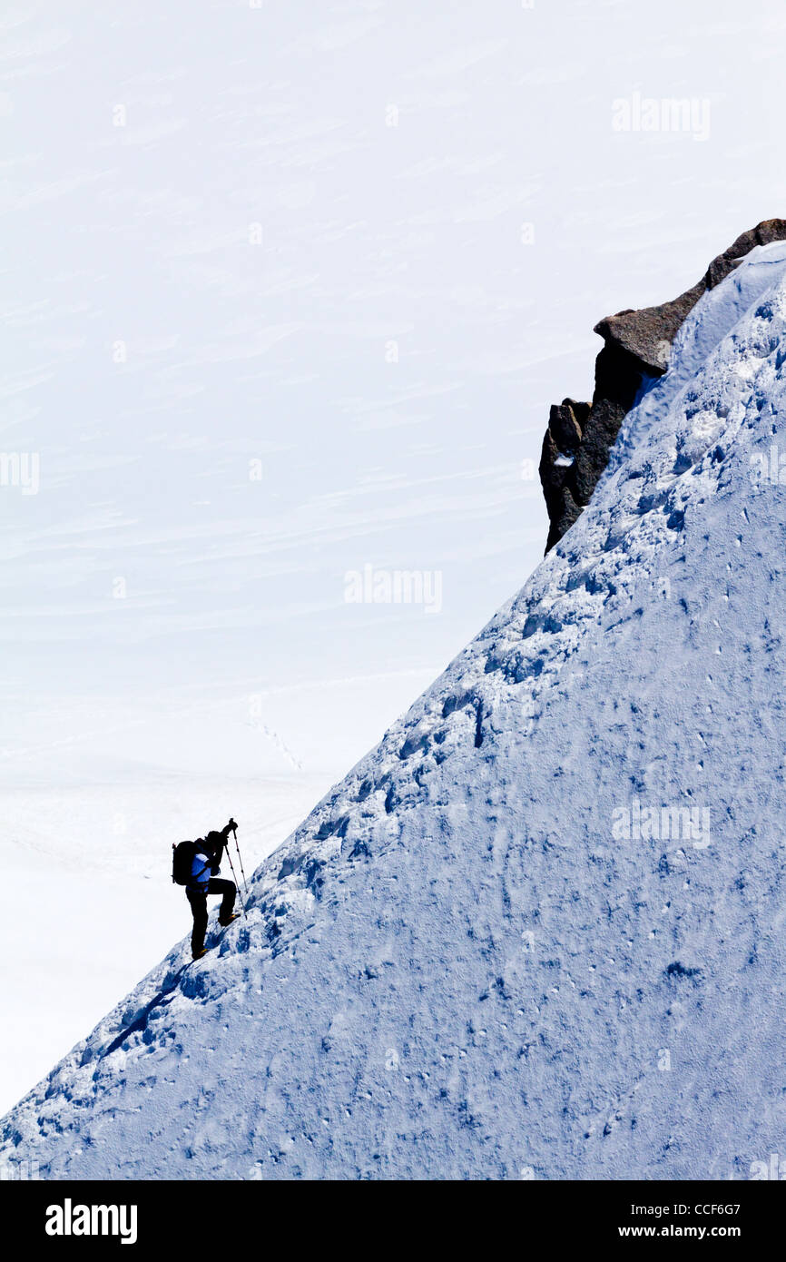 Montañero ascendente cresta cubiertas de hielo en la nieve cerca de la cima del Mont Blanc en los Alpes franceses, el pico más alto de Europa Foto de stock