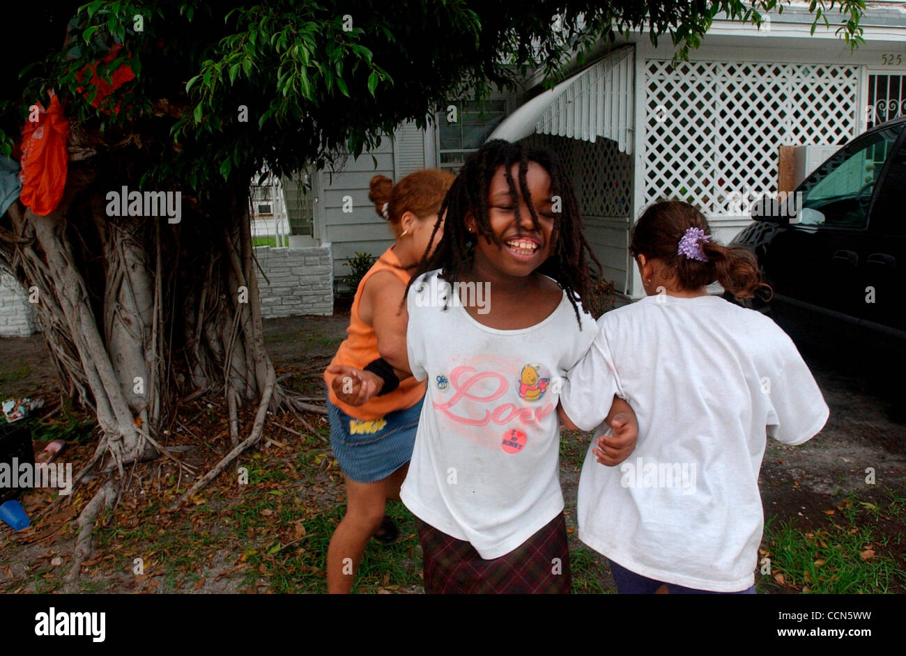 Aug 17, 2004; Miami, FL, EEUU; Iris Scott, 8, centro, Jocelin Oseguera, 11, izquierda y Abnerys Oseguera, 10, derecho, bailar juntos en el barrio de la ciudad de Limón de Miami, FL el martes, 17 de agosto de 2004. Vivir en un barrio diverso en el borde de Little Haití, Scott es el padre de Jamaica y t Foto de stock