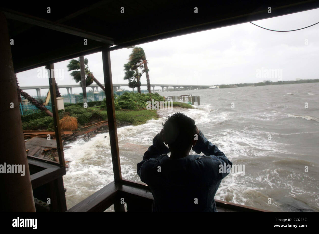 090504 Vero Beach, FL -un residente de Vero Beach mira con prismáticos en  propiedades a través del Indian River Langosta Shanty junto al Indian River  como el Huracán Frances debilita el domingo