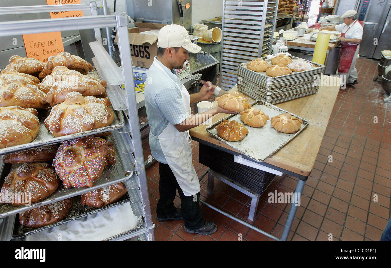 20 de octubre de 2008, en Oceanside, California, Estados Unidos. Baker  Carlos Sánchez se aplica una capa de mantequilla a un pan de muerto el  lunes en una panadería llamada La Perla