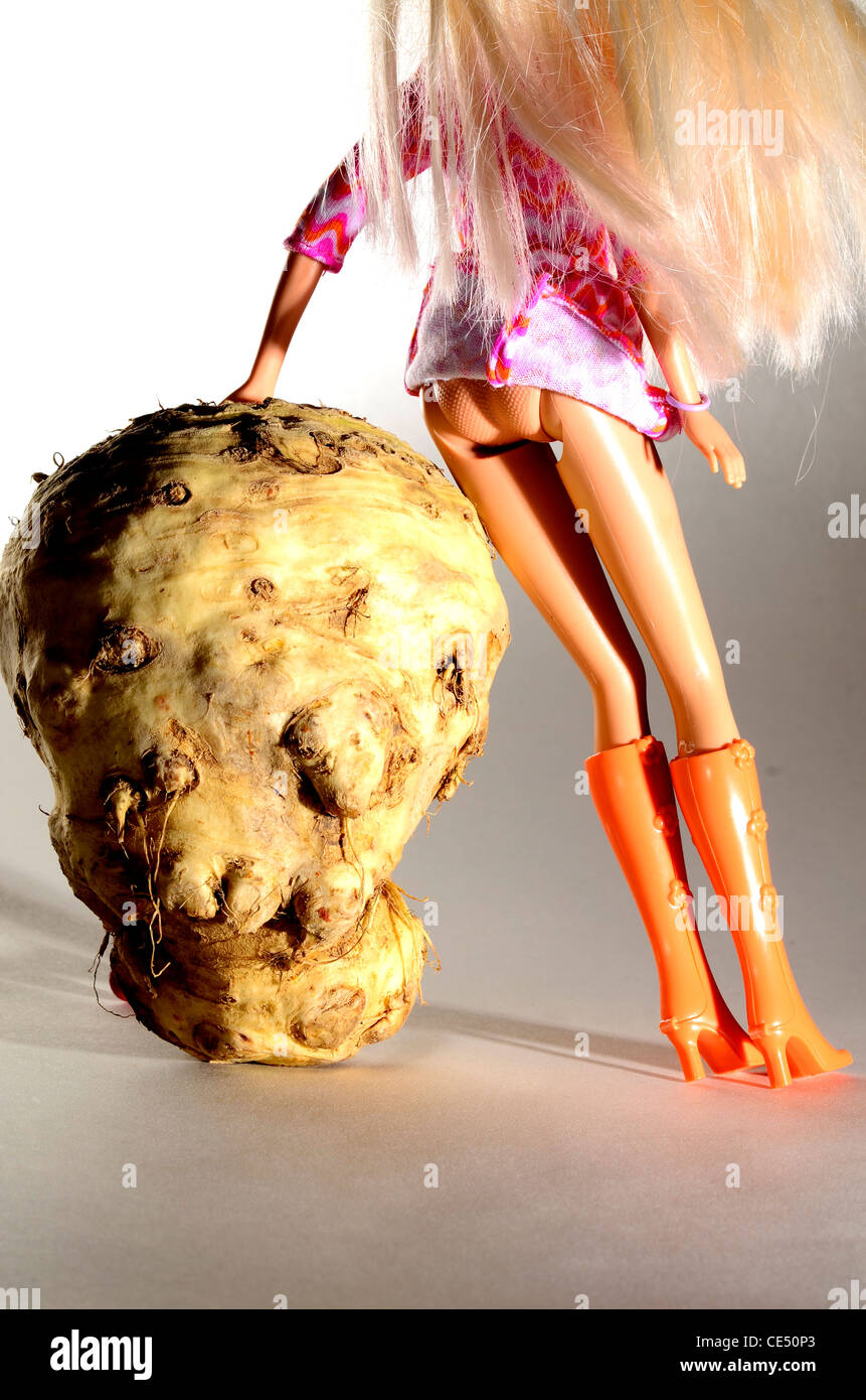 Celeriac vegetal de raíz la forma de cabeza humana con la muñeca Barbie  mostrando su culo y su uso a largo botas naranja Fotografía de stock - Alamy