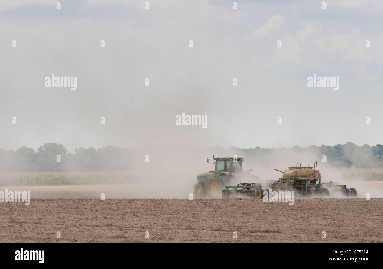 Tractor en una nube de polvo mientras se realiza la aplicación de productos químicos en polvo en el campo cerca de la granja de Hurlock, Maryland Foto de stock