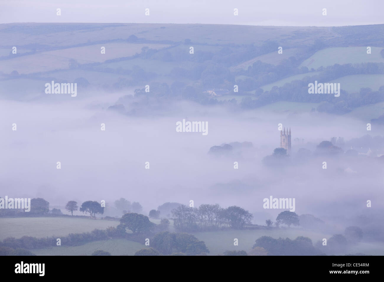 Niebla de la mañana se arremolina alrededor de la torre de la iglesia de Widecombe en el Páramo, Dartmoor, Devon, Inglaterra. Otoño (septiembre de 2011). Foto de stock