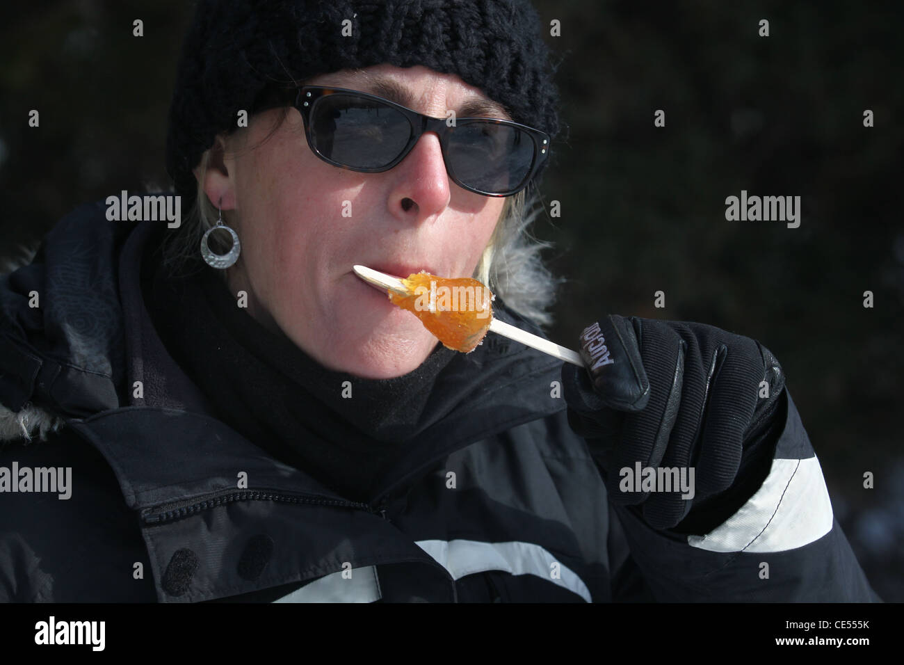 Señora comiendo vierte el azúcar de arce taffy lolipop Foto de stock