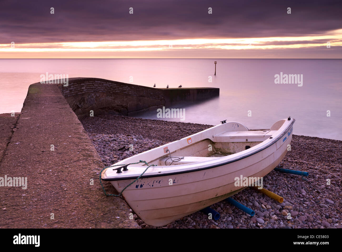 Barco de pesca en Sidmouth playa al amanecer, Sidmouth, Devon, Inglaterra. Invierno (enero de 2012). Foto de stock