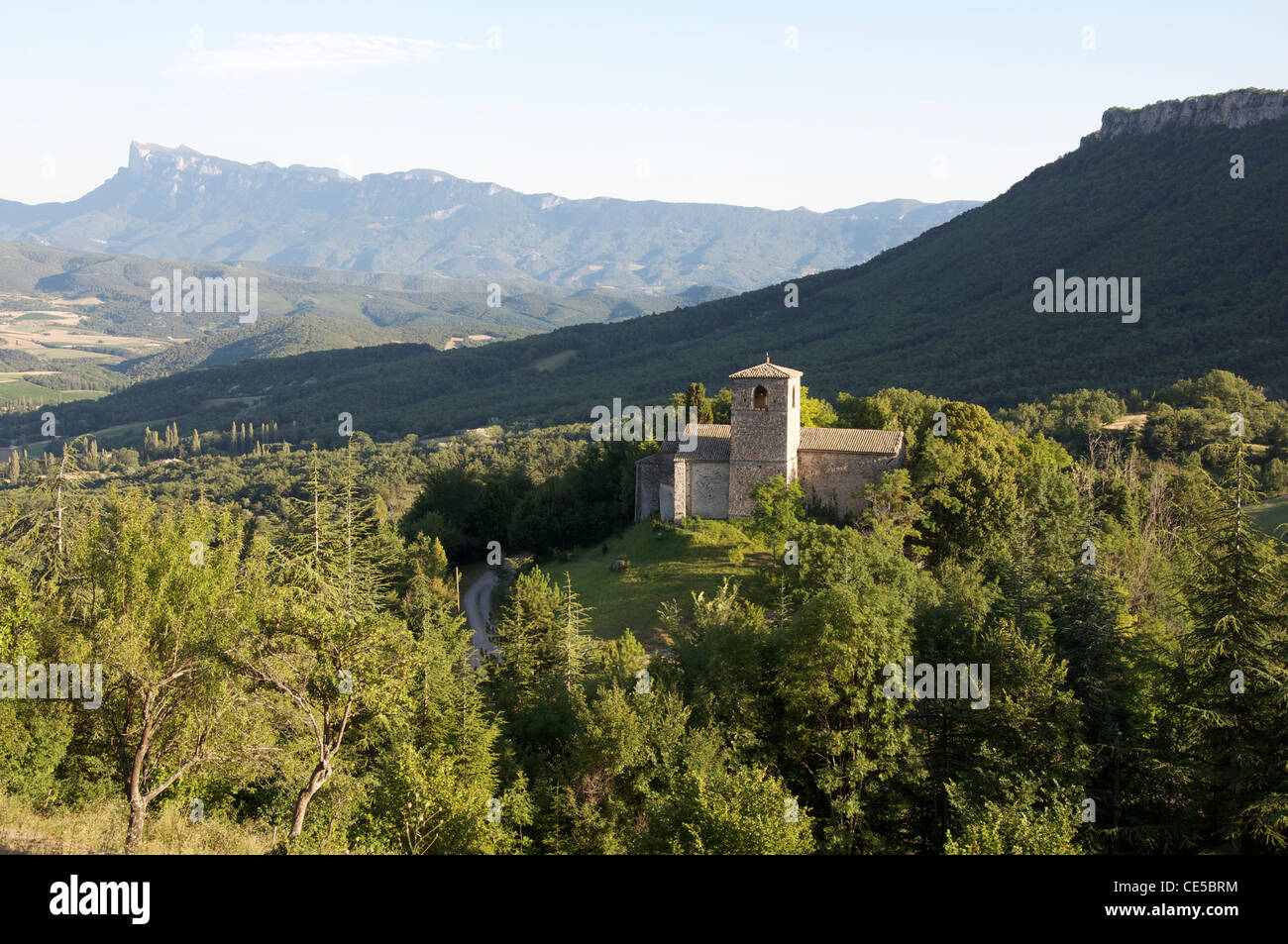 Una vista de la pequeña aldea de Gigors en la cima de la colina de la antigua iglesia románica de San Pedro y el paisaje montañoso del Vercors. La Drôme, Francia. Foto de stock