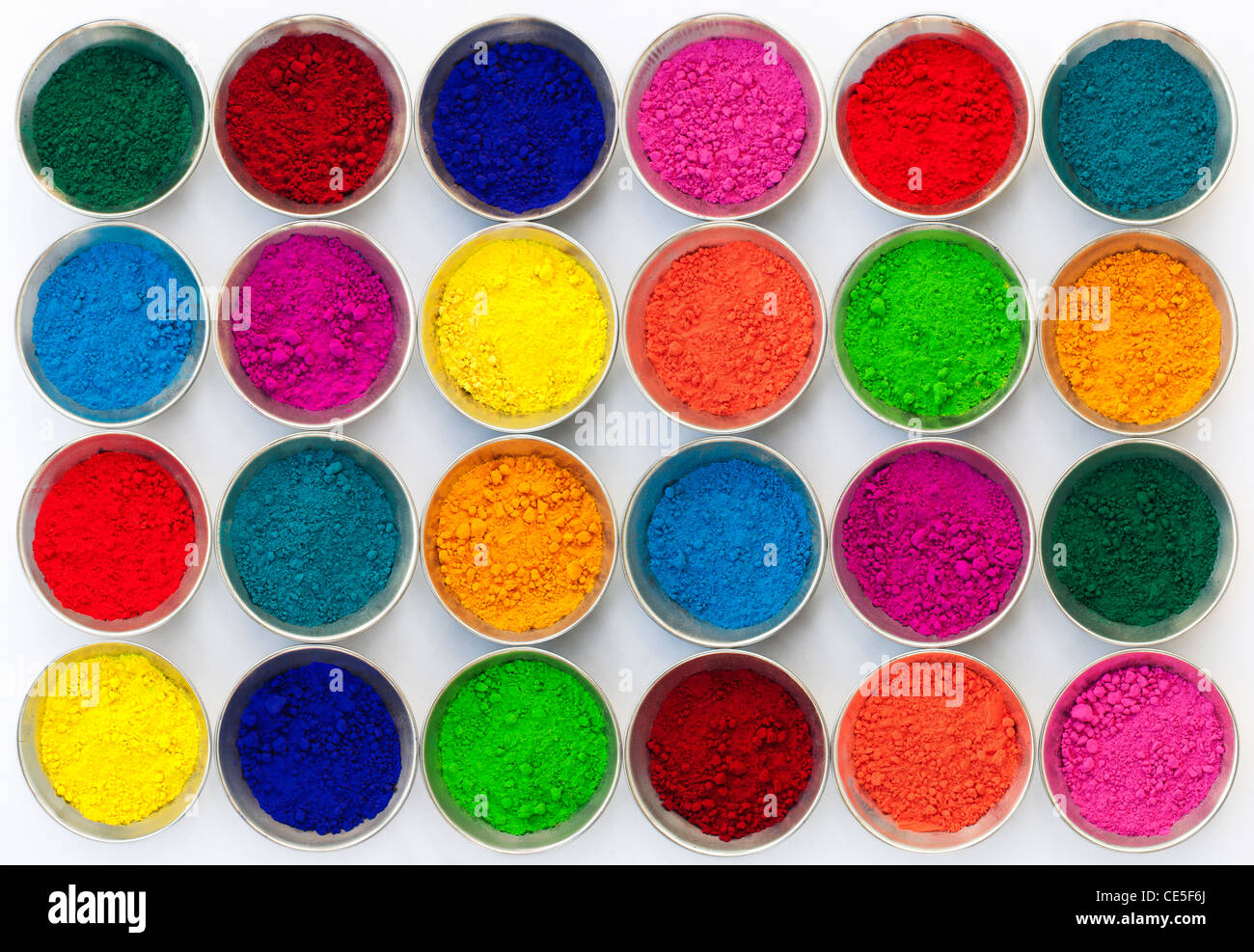Indios de color en polvo en recipientes metálicos utilizados para hacer rangoli diseños. Fondo blanco Foto de stock