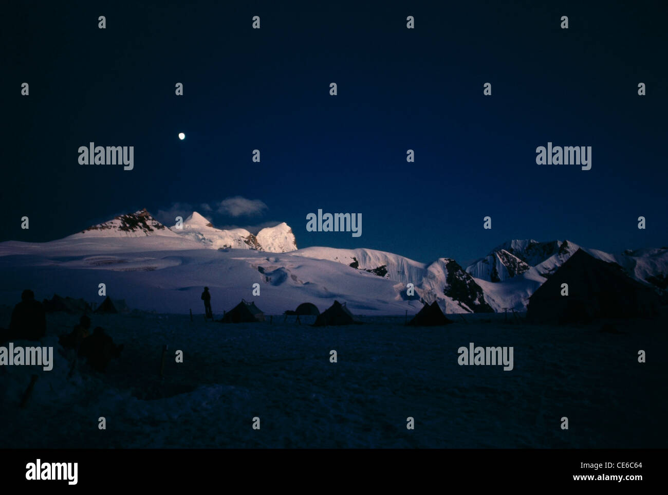Luna sobre cubiertas de nieve de las montañas del Himalaya en el camping pico de la india Foto de stock