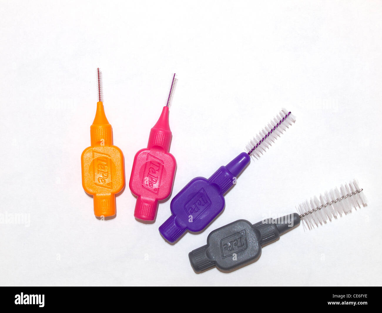 Cuatro entre dental cepillos de diversos tamaños para limpiar entre los dientes dispuestos en forma de abanico Foto de stock