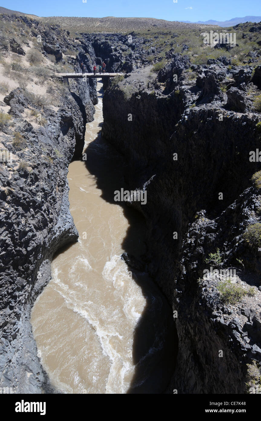 Rio Grande fluyendo a través de cañón cortado a través de basalto volcánico, en el borde del Parque Nacional de La Payunia, Mendoza, Argentina. No, señor Foto de stock