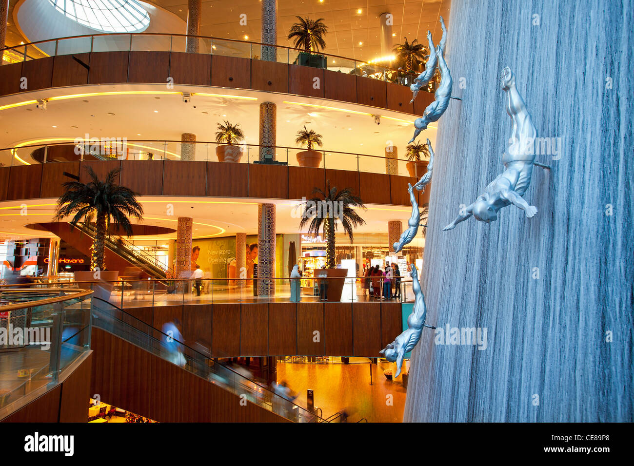 Dubai, cascada y esculturas de buceo hombres dentro del centro comercial Dubai Mall Foto de stock