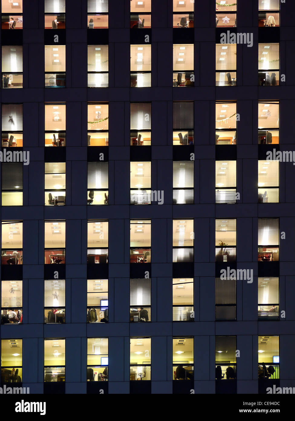 Edificio de oficinas en el exterior al atardecer, con luces interiores Foto de stock
