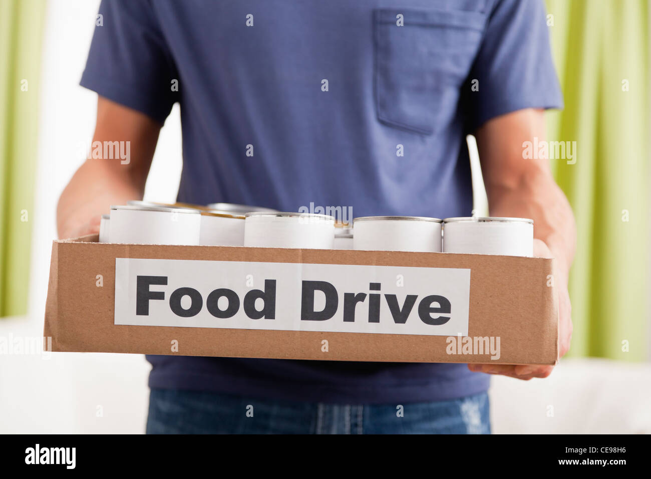 Estados Unidos, Illinois, Metamora, Hombre sujetando la caja de cartón con los alimentos enlatados Foto de stock