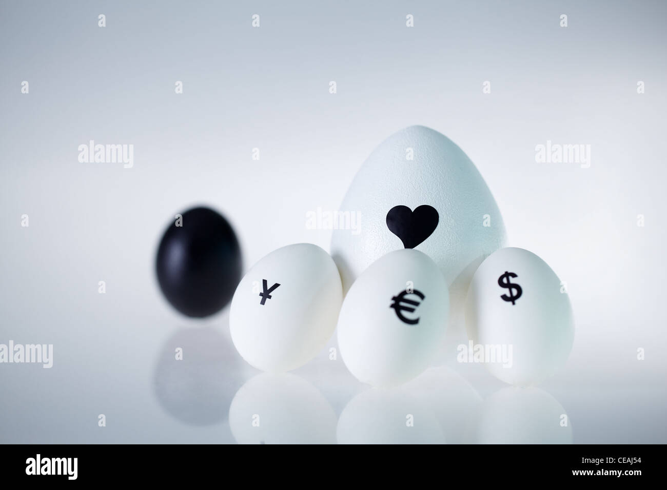 Imagen del gran huevo blanco con corazón rodeado por tres pequeños huevos con signos de moneda Foto de stock