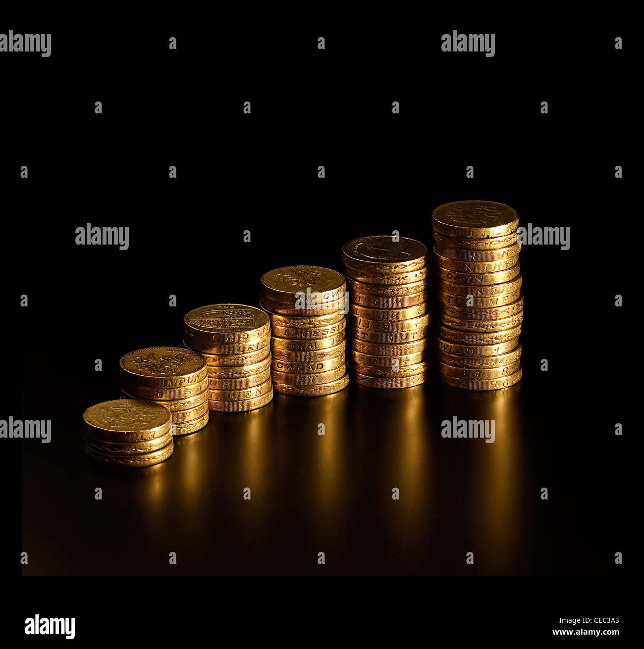 Cada vez más altos montones de British Pound Coins semejando un mayor beneficio gráfico Foto de stock